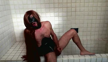 Long Hair Sissy in Corset Uses Gagball in Bathroom