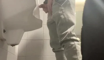 2 Boys in Sneakers Having Fun at Public Toilets' Urinal