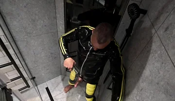 Rubber Man Pisses with Uncut Cock